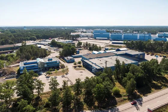 Snickeriet 4 i Oskarshamn från luften: blå industribyggnader omgivna av skog