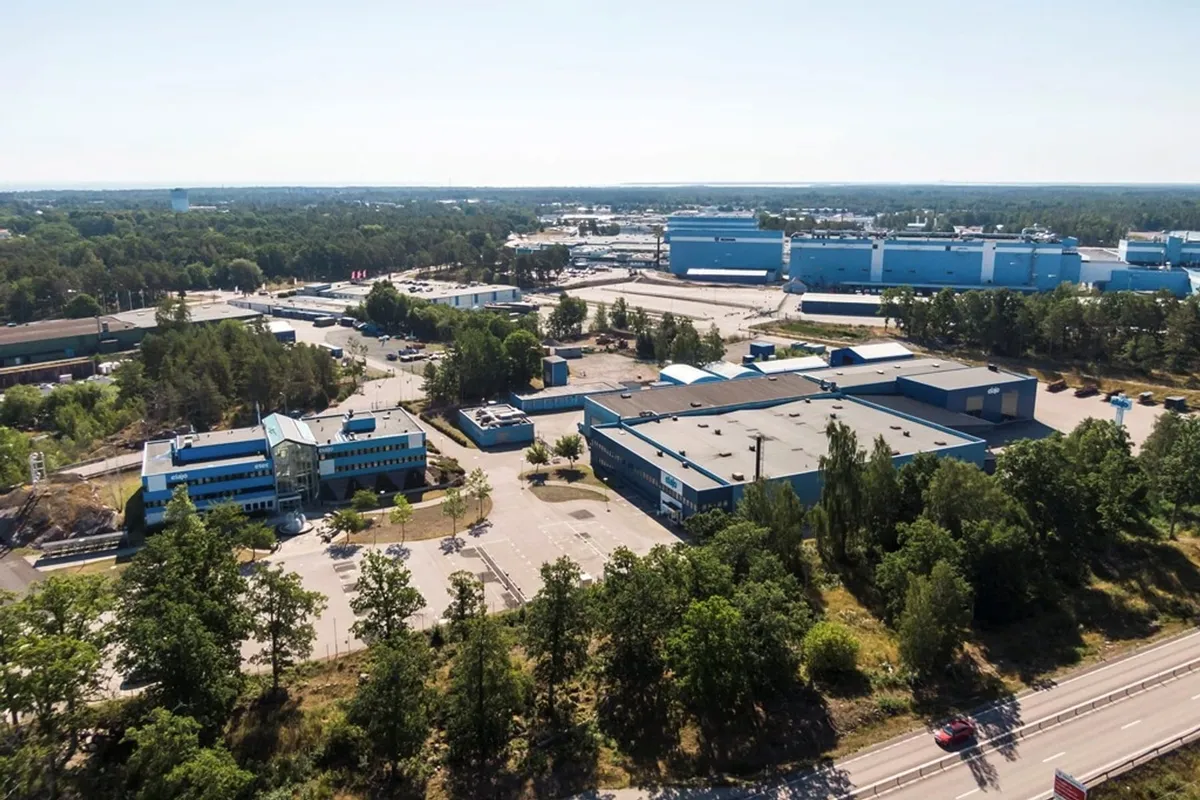 Snickeriet 4 i Oskarshamn från luften: blå industribyggnader omgivna av skog
