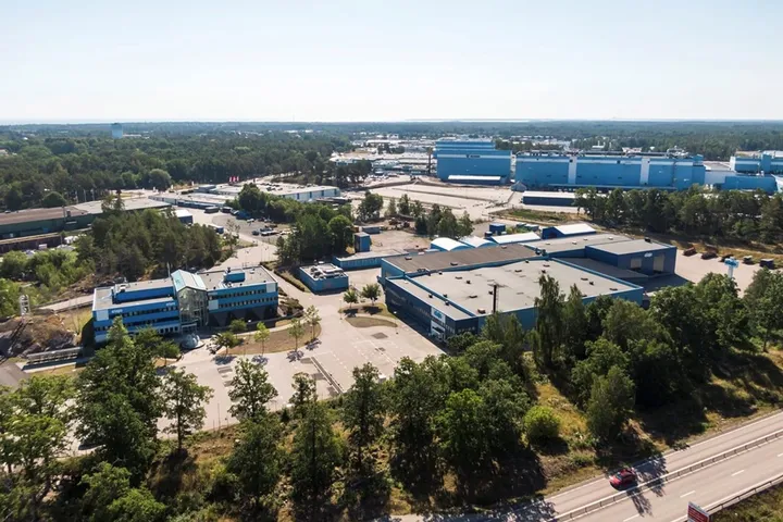 Snickeriet 4 in Oskarshamn from the air: blue industrial buildings surrounded by forest