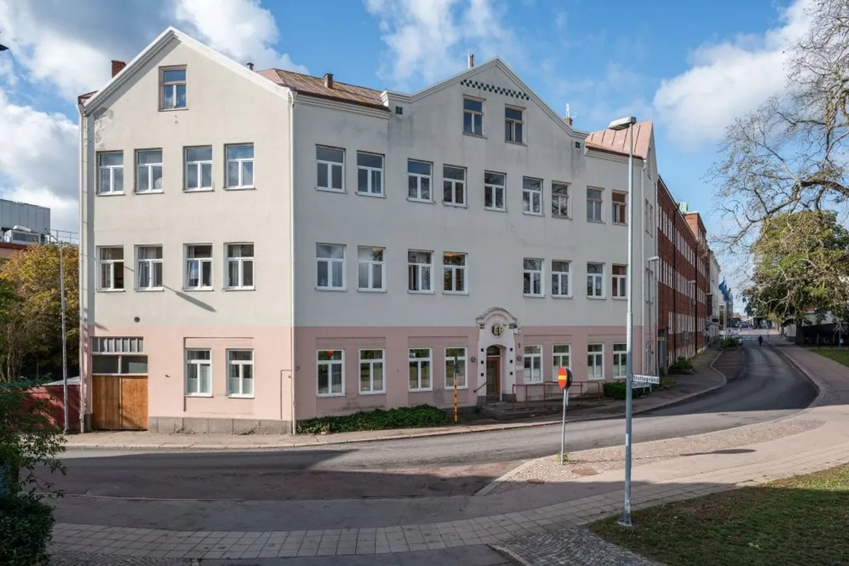 Venus 13 i Oskarshamn: ljust putsat hus i tre våningar vid gatukorsningen